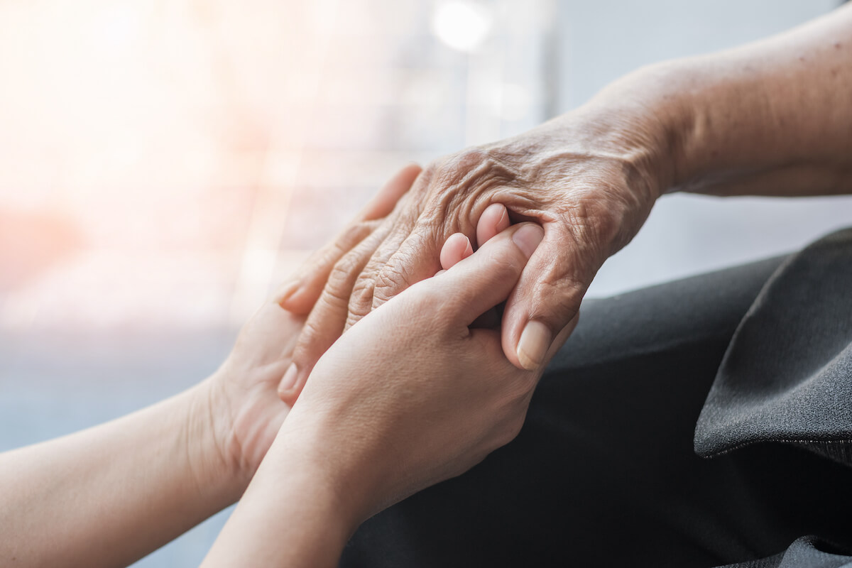 Caregiver holding a senior's hand