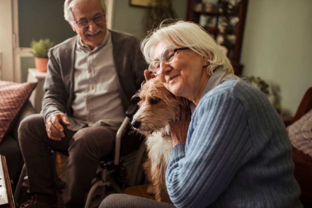Older couple petting their dog