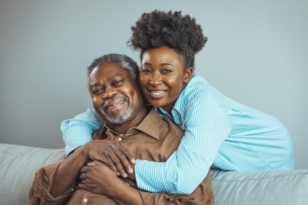 An adult daughter hugging her parent