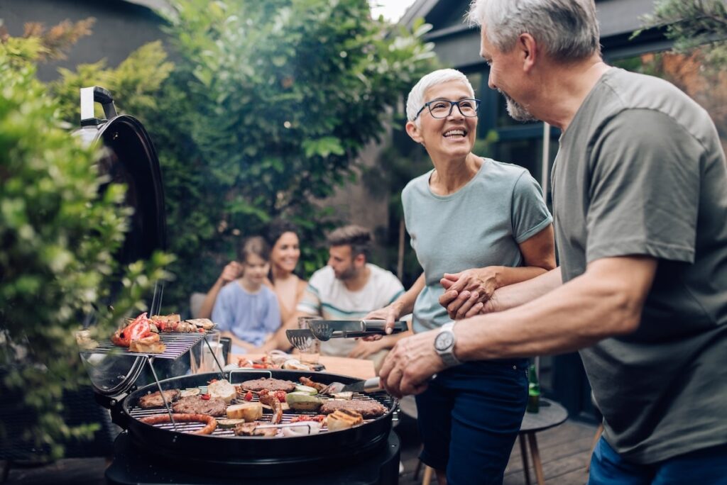 Seniors laugh around the grill