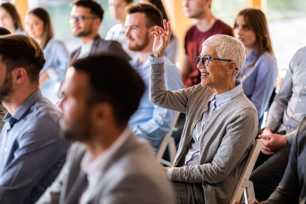 senior raises her hand at seminar