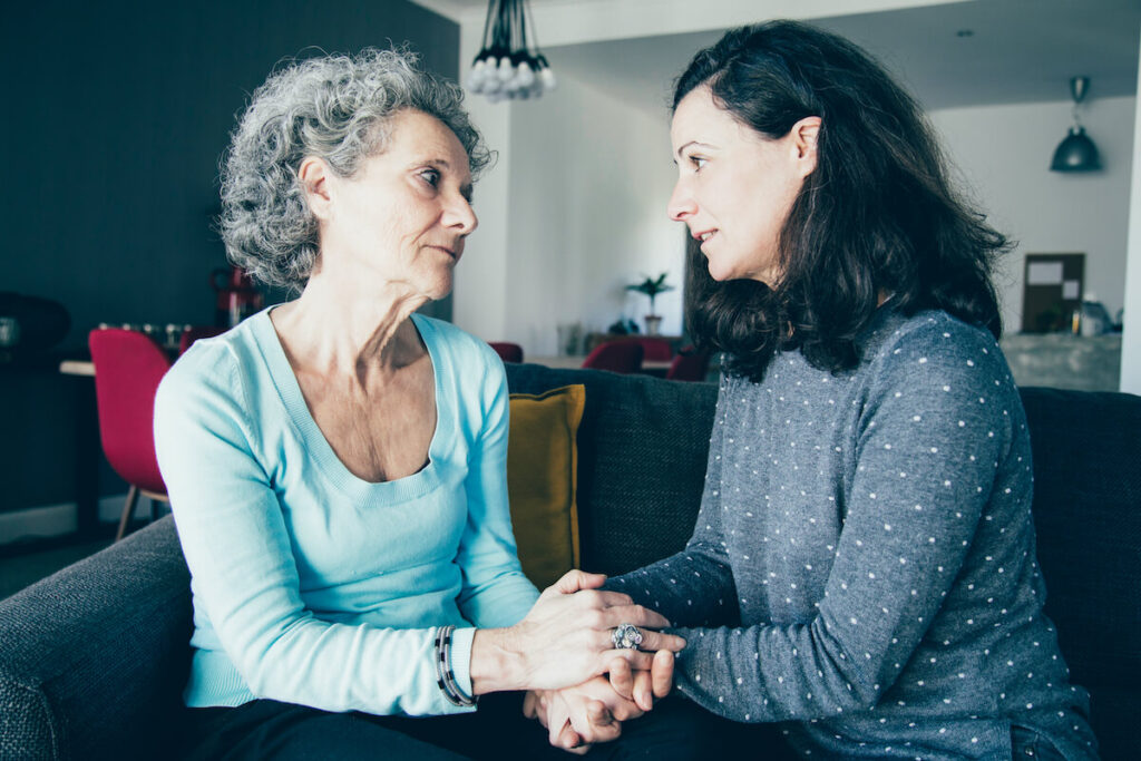 Senior Woman and Adult Daugher Talking on Couch