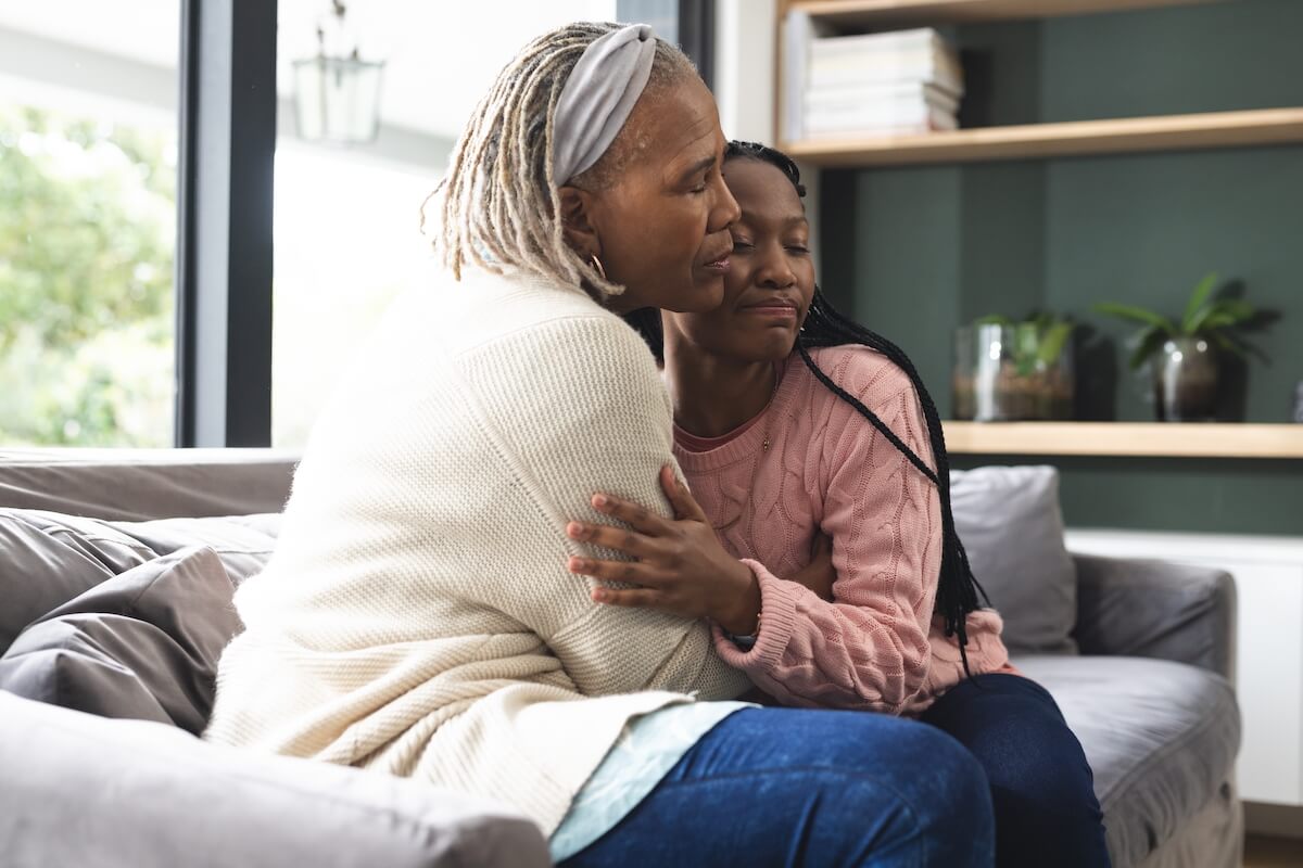 Adult daughter hugging her elderly mom