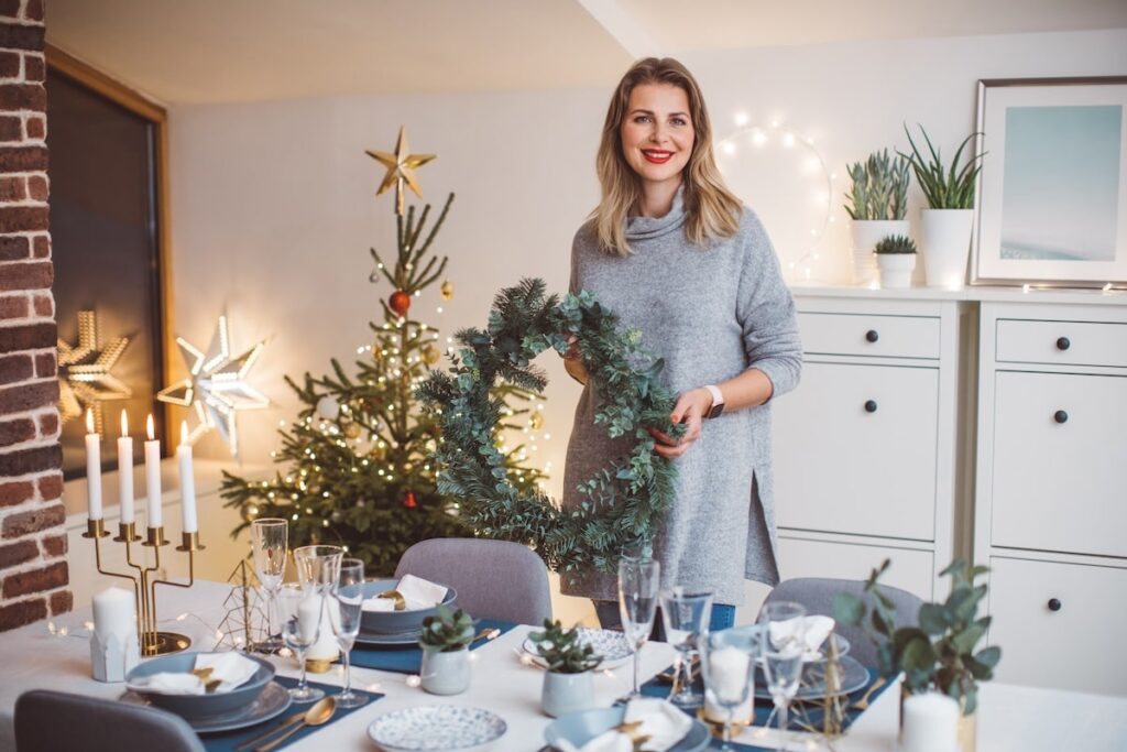 Women holds a wreath and smiles at the dinner table