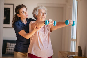 Fitness instructor aiding an elderly woman