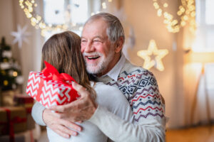 Older adult and his daughter hugging during the holidays
